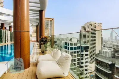 a balcony with white chairs and a view of a city at Modern 1BR in JVC Pool, Gym & Free Parking in Dubai