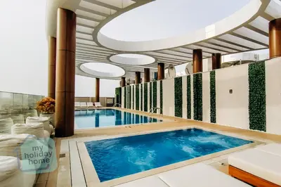a large swimming pool in a room with a ceiling at Modern 1BR in JVC Pool, Gym & Free Parking in Dubai