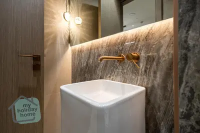 a bathroom with a white toilet and a mirror at Modern 1BR in JVC Pool, Gym & Free Parking in Dubai