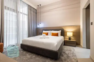 a bedroom with a large bed and a large window at Modern 1BR in JVC Pool, Gym & Free Parking in Dubai