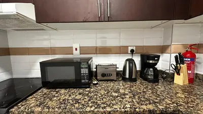 a kitchen counter with a microwave and a coffee maker at Stylish 1BR Canal View Apartment Business Bay in Dubai