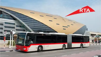 a red and white bus parked in front of a building at Stylish 1BR Canal View Apartment Business Bay in Dubai