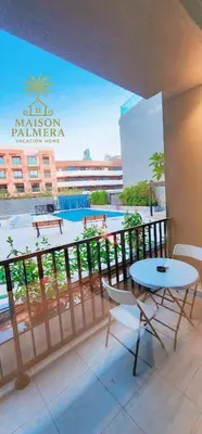 a balcony with a table and chairs and a pool at Park Vista-Infinity Pool View in Dubai