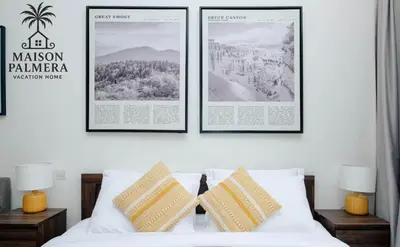 three framed pictures on a wall above a bed at Park Vista-Infinity Pool View in Dubai