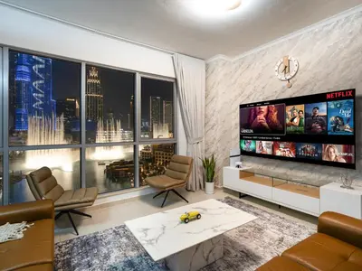 a living room with a large flat screen tv at Panoramic Burj 5br Condo with Full Led & Fountain View in Dubai