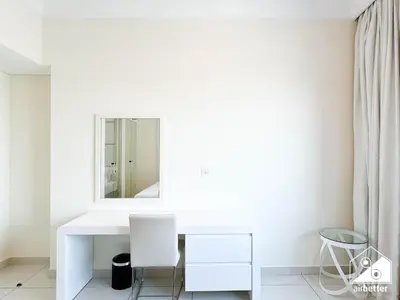a white bathroom with a mirror and a white desk at Luxury Living Skyline Views l 2BR with Pool & Gym in Dubai