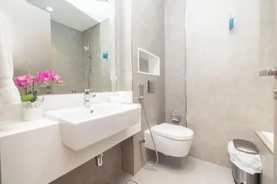 a white bathroom with a sink and a toilet at Modern & Luxurious 2BR Penthouse in MBR City District One Dubai in Dubai