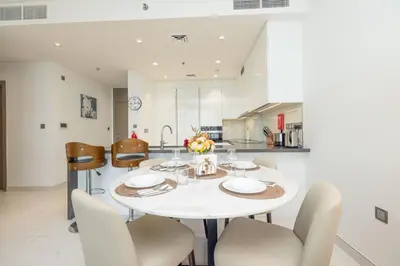 a kitchen and dining room with a white table and chairs at Modern & Luxurious 2BR Penthouse in MBR City District One Dubai in Dubai