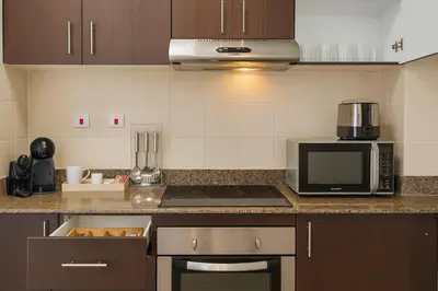 a kitchen with a microwave and a stove top oven at Marina 2BR 58th Floor Sea and City Views Pool Gym in Dubai