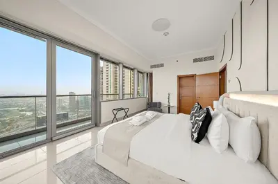 a bedroom with a large bed and large windows at Elegant 2BR with Panoramic Marina View in Dubai