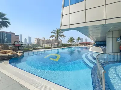 a large swimming pool next to a building at Elegant 2BR with Panoramic Marina View in Dubai