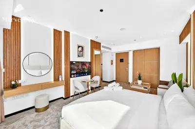 a bedroom with a white bed and a living room at MarvelStay - Connected to Mall & Metro - JW Marriott in Dubai