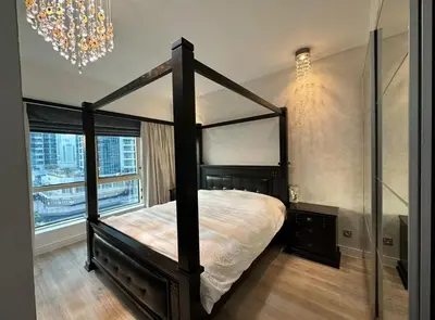 a bedroom with a canopy bed and a chandelier at JLT Luxury New 2BHK in Dubai