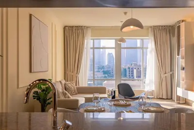 a living room with a table and a couch at Grand 1bhk burj khalifa view Downtown in Dubai
