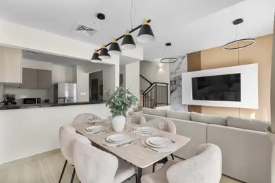 a dining room and living room with a table and chairs at Luxury 4BR Villa Free Malibu Beach Access in Dubai