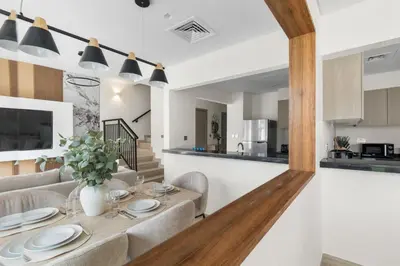 a dining room and living room with a table and chairs at Luxury 4BR Villa Free Malibu Beach Access in Dubai