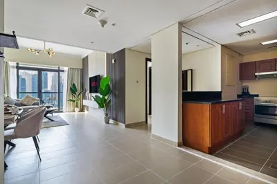 a kitchen and living room with a couch and a table at Luxury JLT 1BR 2 Beds in Room Lakeview & Pool in Dubai