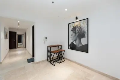 a hallway with a table and a painting on a wall at Comfort Ensuite with Balcony in Dubai