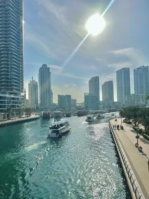 a boat in a river in a city with buildings at Comfort Ensuite with Balcony in Dubai