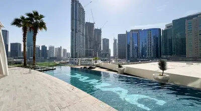 a swimming pool on the roof of a building with a city at Poolside Studio with Canal Views and Near Dubai Mall in Dubai