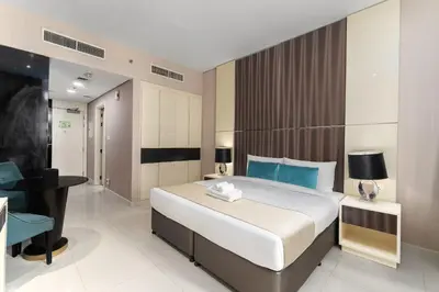 a bedroom with a large bed and a desk in a room at Poolside Studio with Canal Views and Near Dubai Mall in Dubai