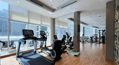a gym with treadmills and ellipticals in a building at Poolside Studio with Canal Views and Near Dubai Mall in Dubai