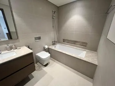 a bathroom with a tub and a toilet and a sink at Grande in Dubai