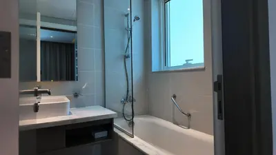 a bathroom with a tub and a sink and a shower at Damac Maison Prive in Dubai