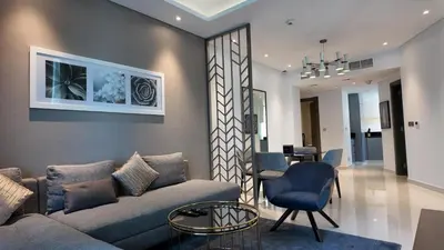 a living room with a couch and a table at Damac Maison Prive in Dubai