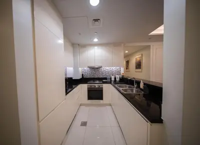 a large kitchen with white cabinets and a sink at Amazing Burj Khalifa Views with Highest Infinity pool in Dubai