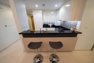 a kitchen with two stools at a kitchen counter at Amazing Burj Khalifa Views with Highest Infinity pool in Dubai