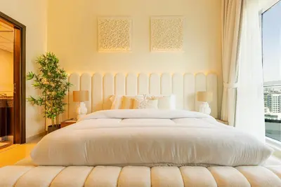 a bedroom with a large white bed with a large window at Bright 1bhk Full Marina View in Dubai