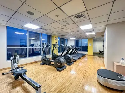 a gym with a row of treadms and cardio machines at Bright 1bhk Full Marina View in Dubai