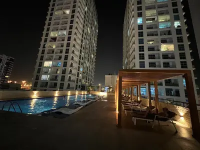 a pool in a city at night with tall buildings at Stylish 1-Bedroom Apartment in the Heart of Dubai Marina in Dubai