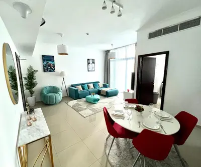a living room with a white table and red chairs at Stylish 1-Bedroom Apartment in the Heart of Dubai Marina in Dubai