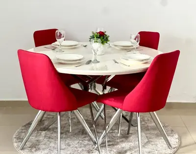 a table with red chairs and a white table with wine glasses at Stylish 1-Bedroom Apartment in the Heart of Dubai Marina in Dubai