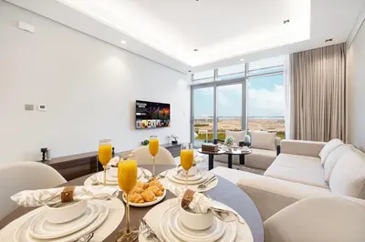 a living room with a table and a couch at Deluxe Nobles Suites by Hostiva - Garden View in Dubai