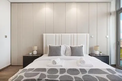 a bedroom with a large bed with two towels on it at Deluxe Nobles Suites by Hostiva - Garden View in Dubai