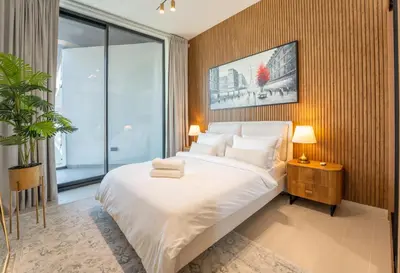 a bedroom with a large bed and a large window at Cozy Apartment Gym and Pool Heart of JVC in Dubai