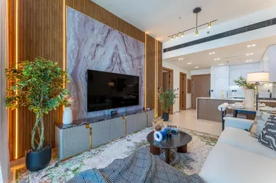 a living room with a large tv on a wall at Cozy Apartment Gym and Pool Heart of JVC in Dubai