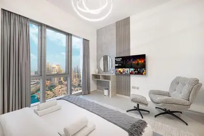 a bedroom with a bed and a large window at Grande Altura Burj & Fountain view 57 floor in Dubai