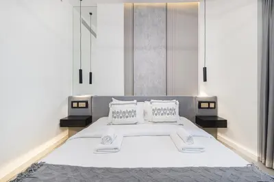 a bedroom with a large white bed with two pillows at Grande Altura Burj & Fountain view 57 floor in Dubai