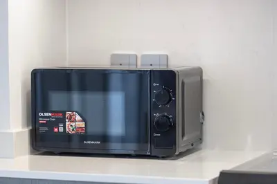 a microwave sitting on top of a counter at Grande Altura Burj & Fountain view 57 floor in Dubai