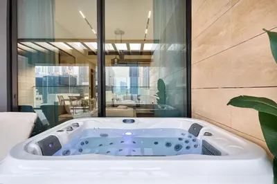 a bath tub in a room with a large window at 1BR Apartment with Private Jacuzzi & Burj Khalifa Skyline in Trillionaire Residences By Binghatti in Dubai