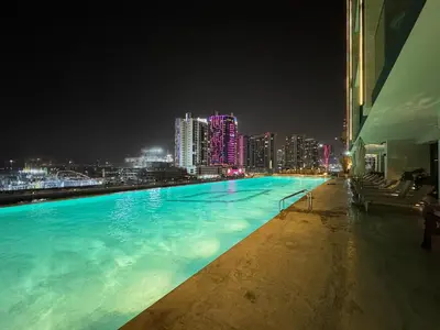 a swimming pool with a city skyline at night at 1BR Apartment with Private Jacuzzi & Burj Khalifa Skyline in Trillionaire Residences By Binghatti in Dubai