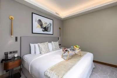 a bedroom with a large white bed and a table at Maison Privee - Fabulous Apt with Sensational Burj Khalifa Views in Dubai