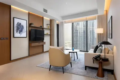 a living room with a couch and a tv at Maison Privee - Fabulous Apt with Sensational Burj Khalifa Views in Dubai