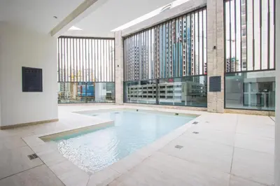 an indoor pool in a building with windows at 1BR Paragon Tower Burj Khalifa & Canal Views in Dubai