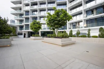 a courtyard in front of a building with a tree at 1BR Paragon Tower Burj Khalifa & Canal Views in Dubai