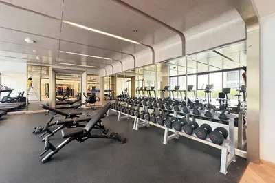 a gym with rows of exercise bikes and treadmills at Modern & Elegant Studio Apartment in Azizi Riviera in Dubai